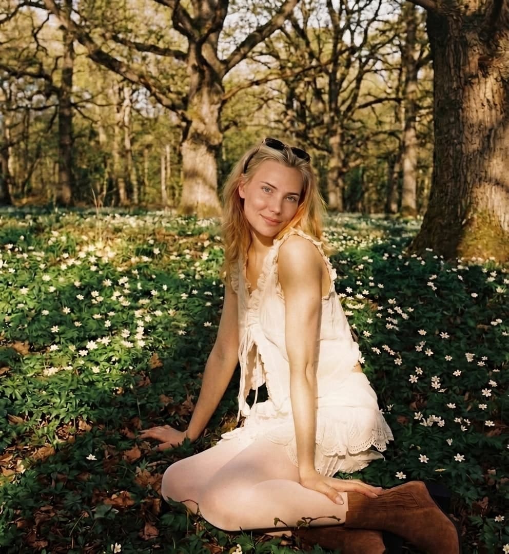 Felicia van Eijk sitting among wood anemones beneath oak trees